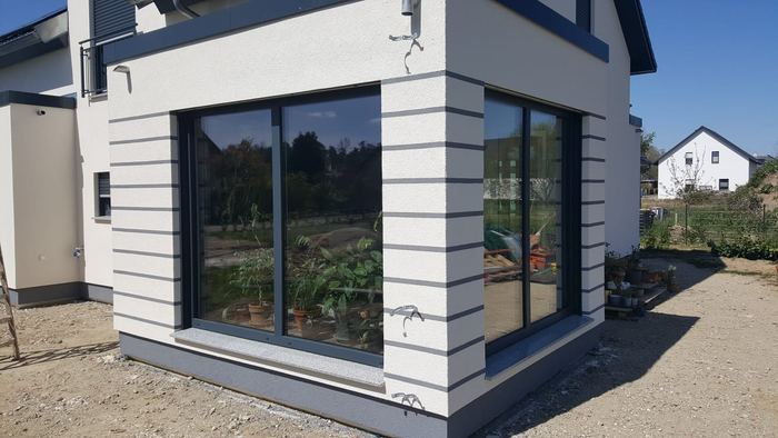 Fassade mit moderner heller Gestaltung und dunklen Akzentstreifen
